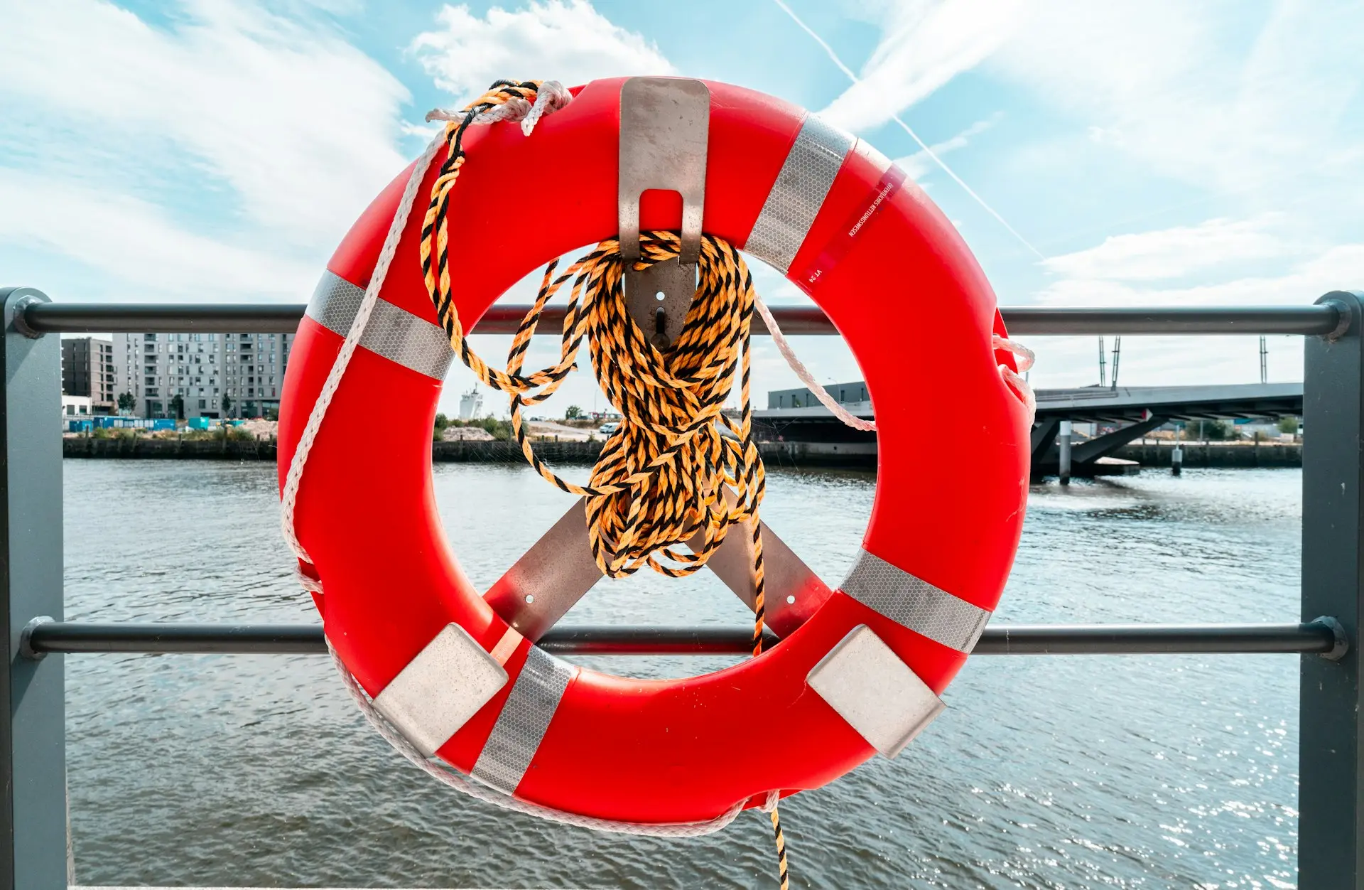 A life preserver hanging on a railing over a body of water